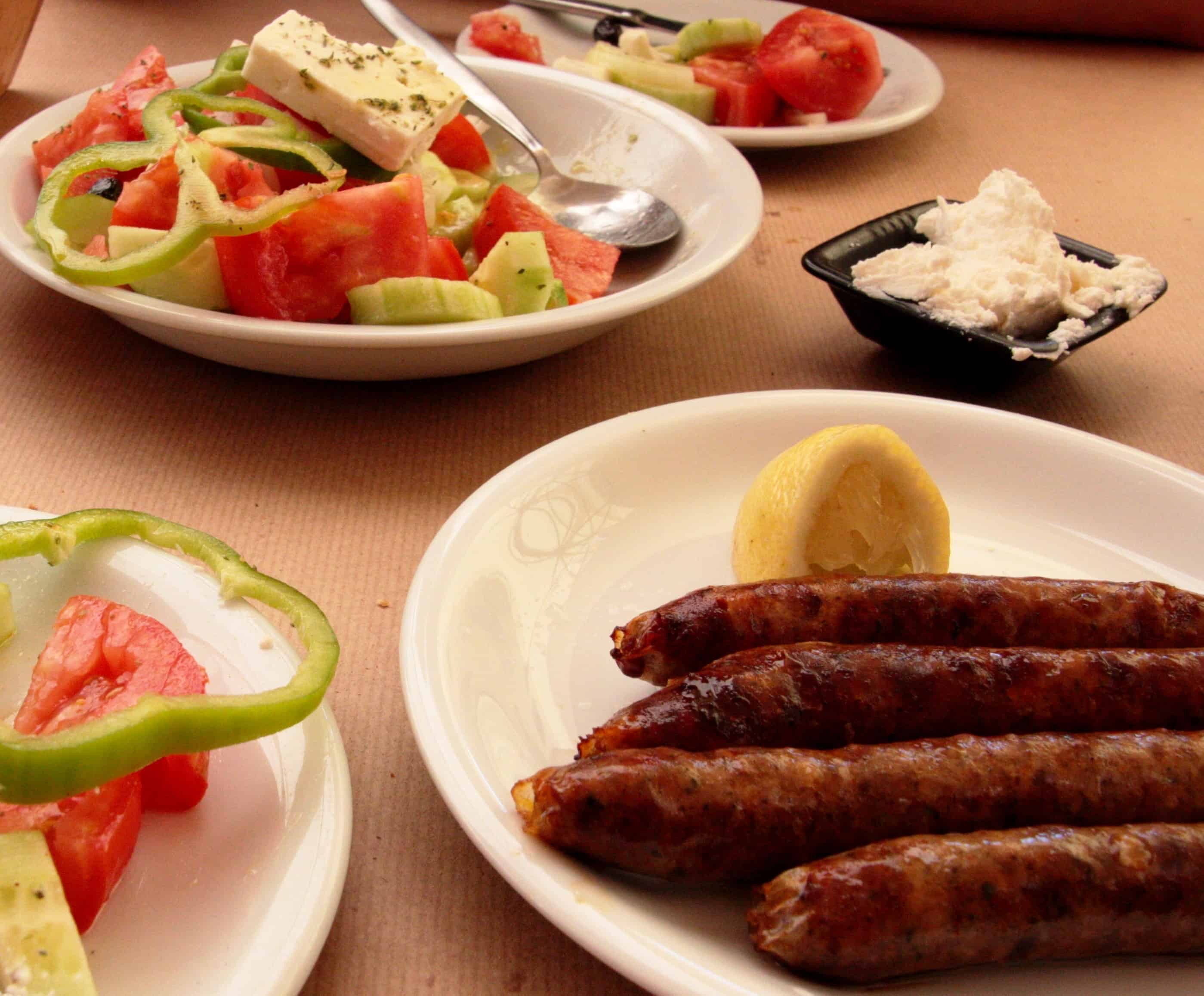 Greek Salad and country sausages make up a simple but amazing dinner when you're visiting the Greek Islands.