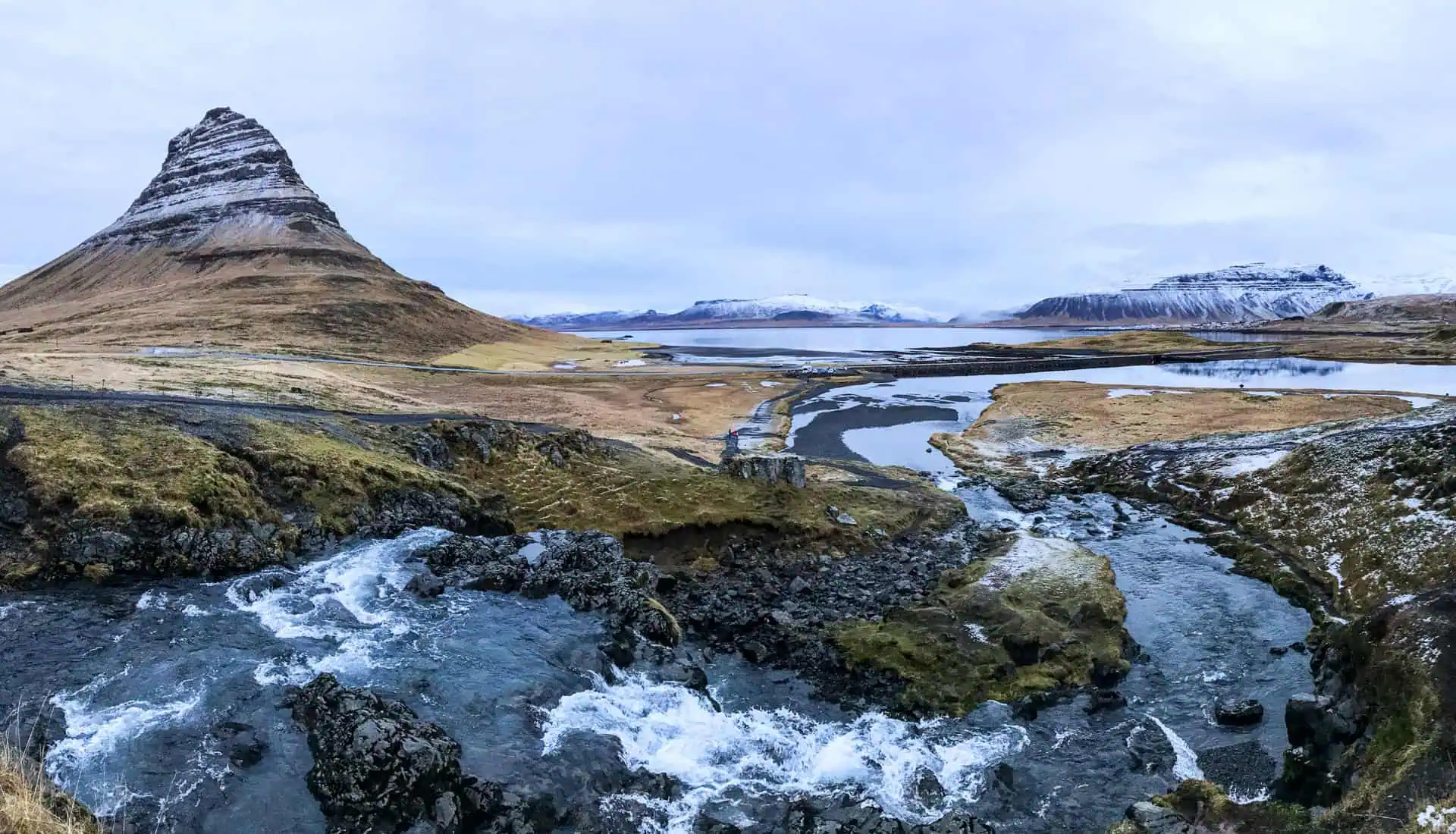 Kirkjufell mountain and waterfall with a wintery backdrop – a highlight of our Iceland road trip.