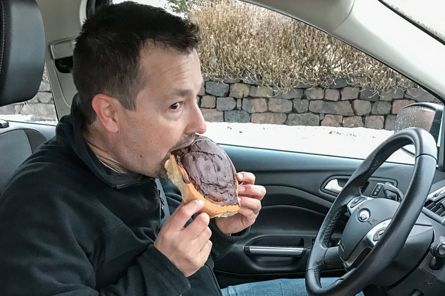 Eating a chocolate-covered Snúðar from Geirabakarí Kaffihús as we start to road trip Iceland on Day One of our itinerary.