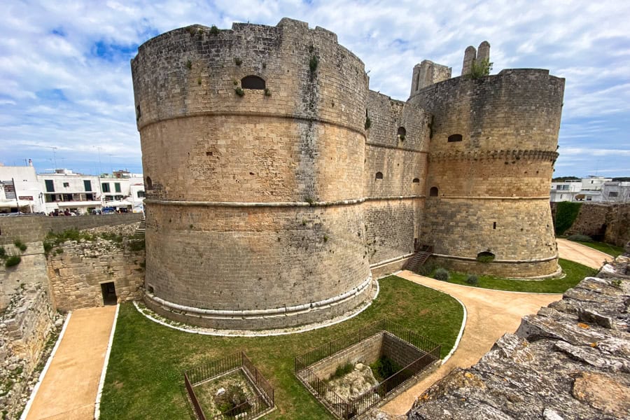 Two stocky round towers rise out of a grassy moat in Otranto, top spot when you visit Puglia.