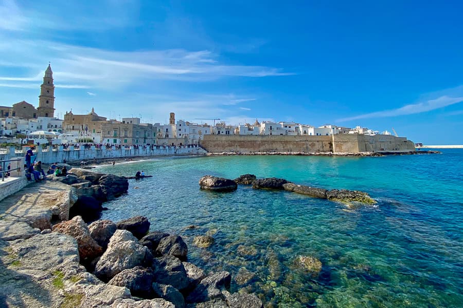 A glittering bay laps the stone walls of Monopoli, one of the best towns in Puglia to visit.