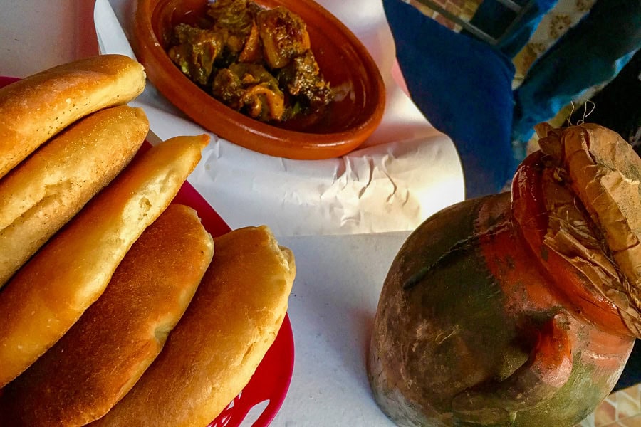 Tasty lamb stew baked in a terracotta pot with freshly baked khobz bread – traditional street food in Morocco.